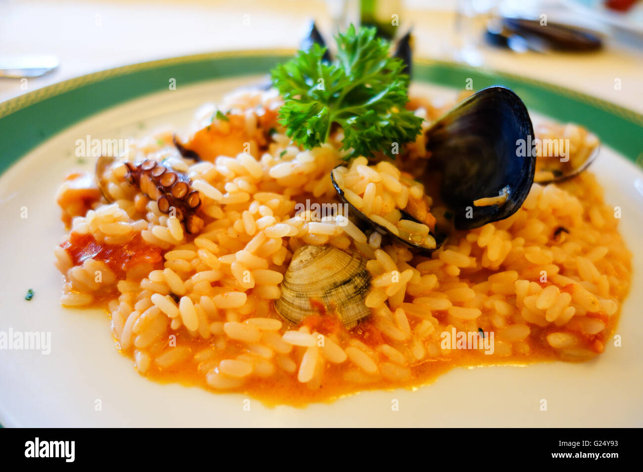 A plate of seafood risotto with rice mussels squid calamari and various