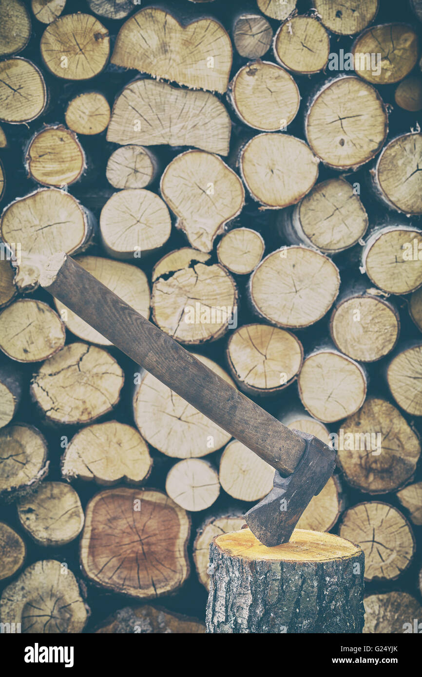 Retro stylized photo of an old axe in a stump. Stock Photo