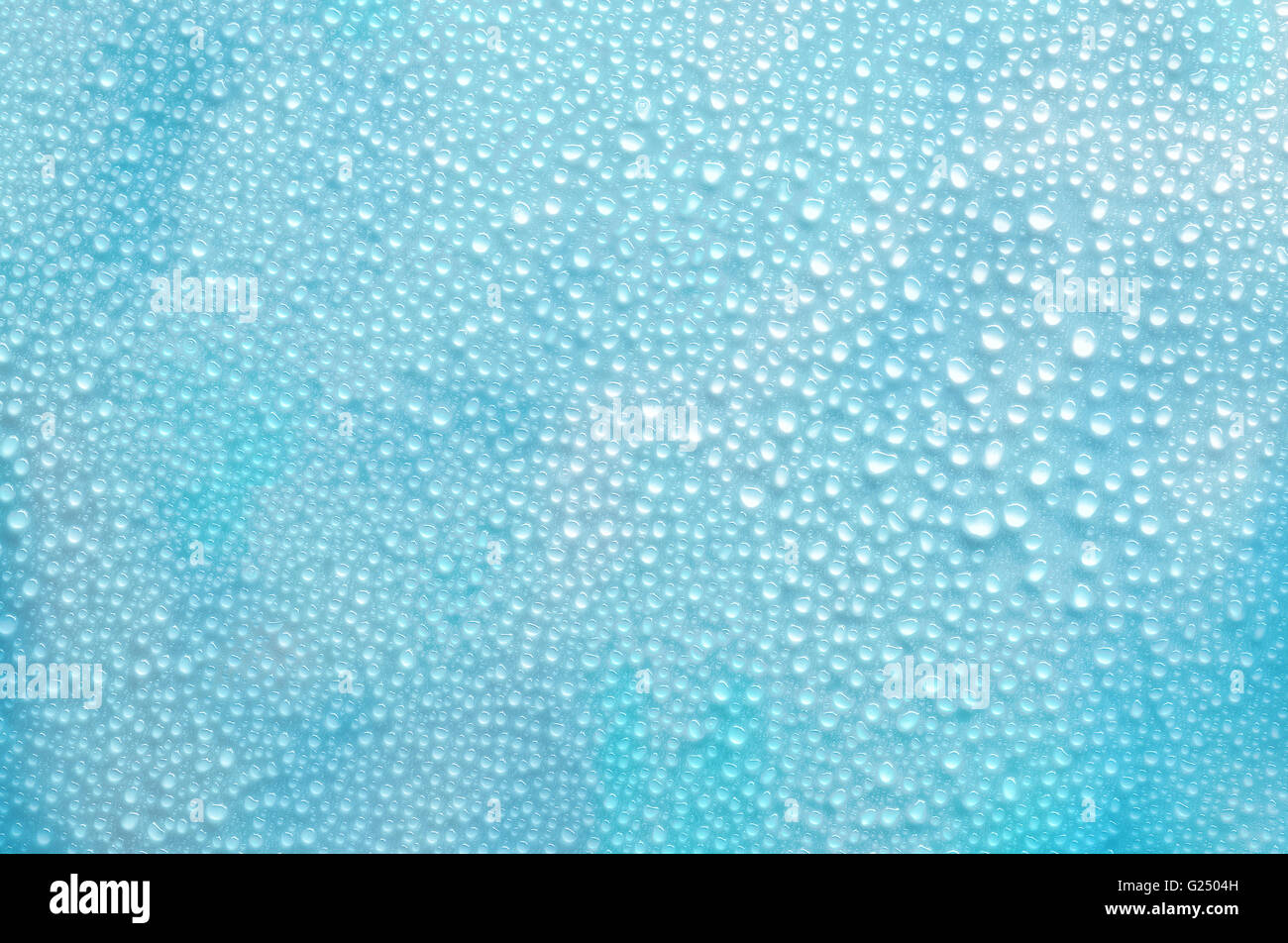 Water droplets on a flat surface, blue background Stock Photo