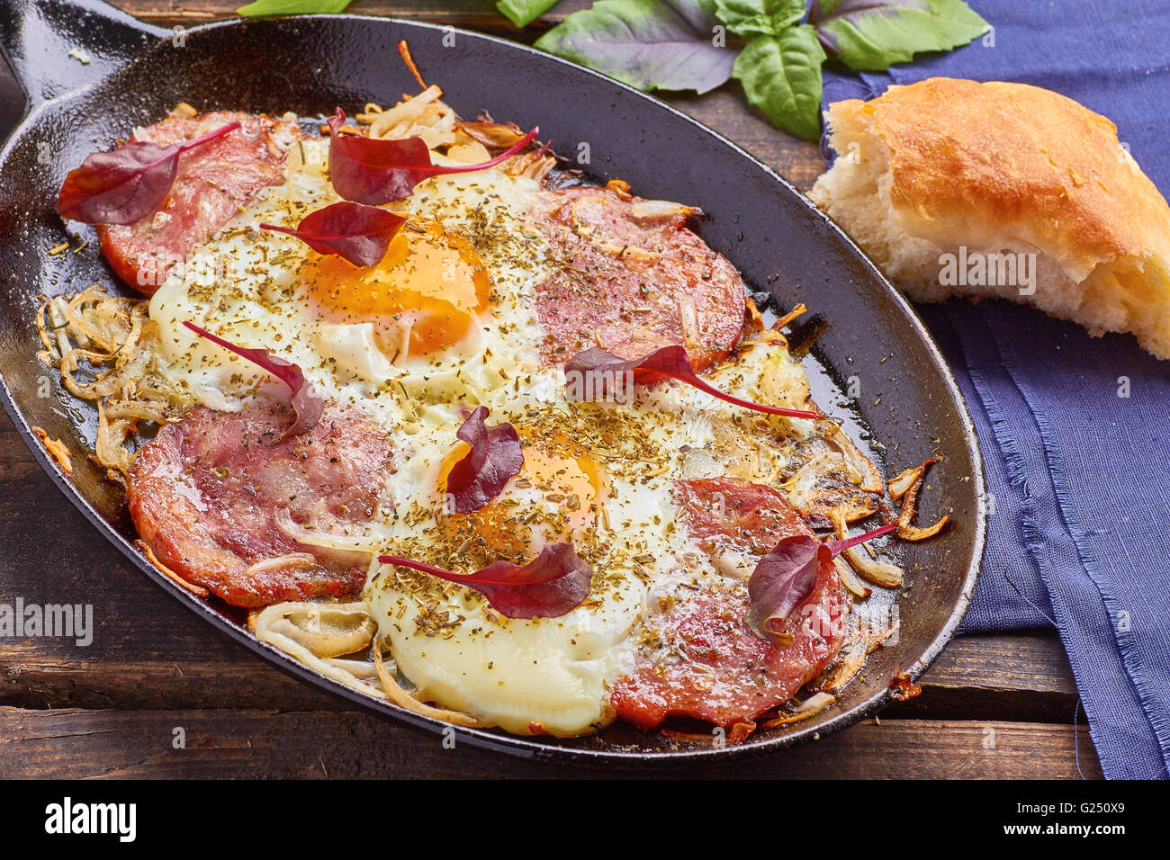 Pan of fried eggs with onion, ham and chard Stock Photo