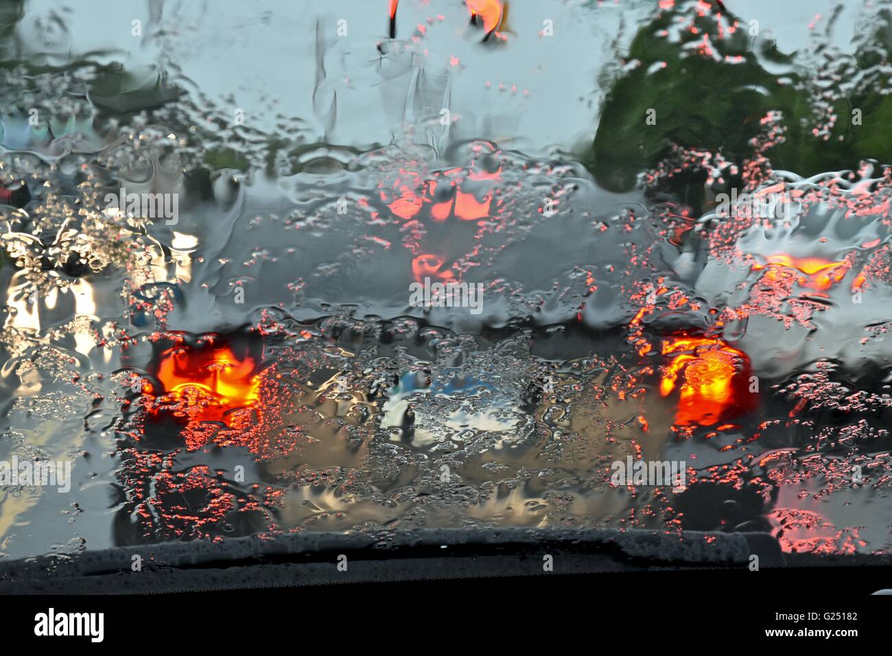 Driving a car during a rainy day, causing unsafe driving conditions Stock Photo