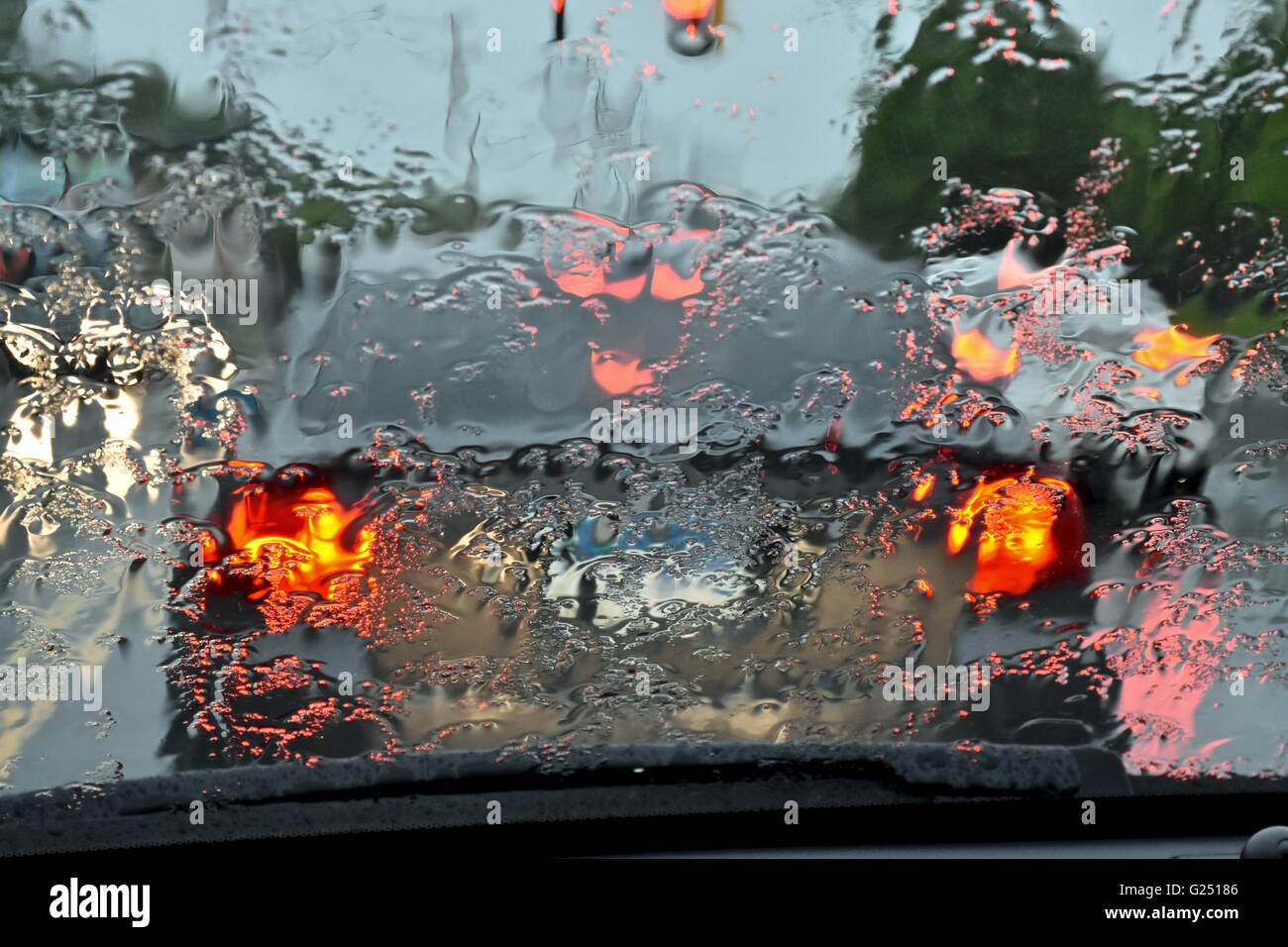 Driving a car during a rainy day, causing unsafe driving conditions Stock Photo