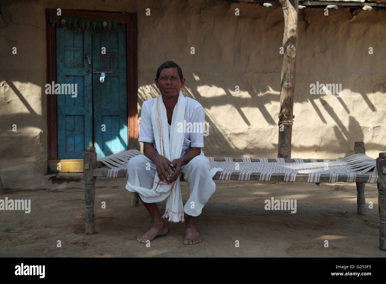 KOLAM TRIBE - ( Menarwar )- Man in traditional outfit sitting on a cot. Sonapur, Post Mandawa, Maharashtra, India Stock Photo