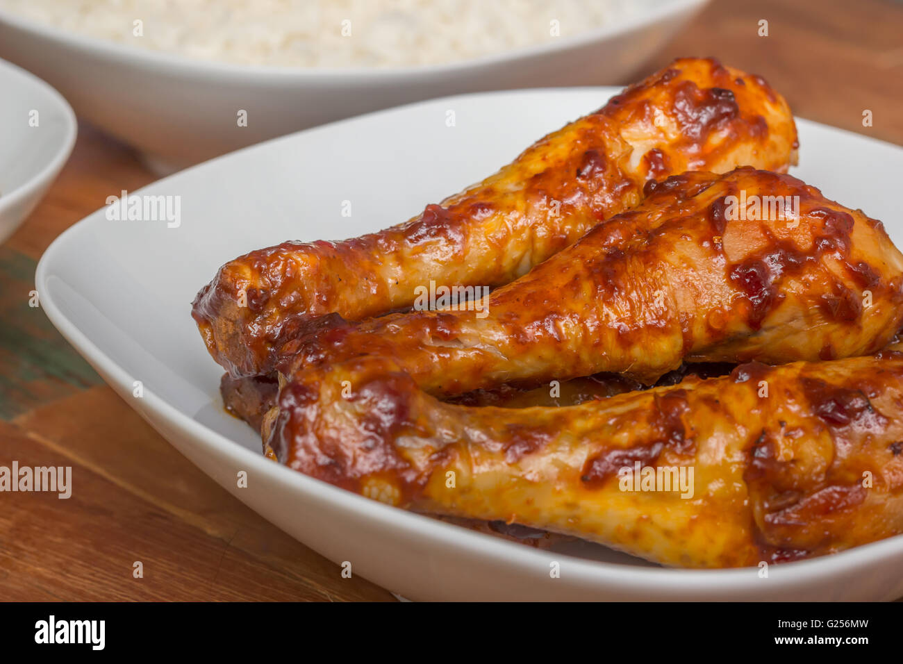 Marinated Indonesian chicken drumsticks with rice on a white plate
