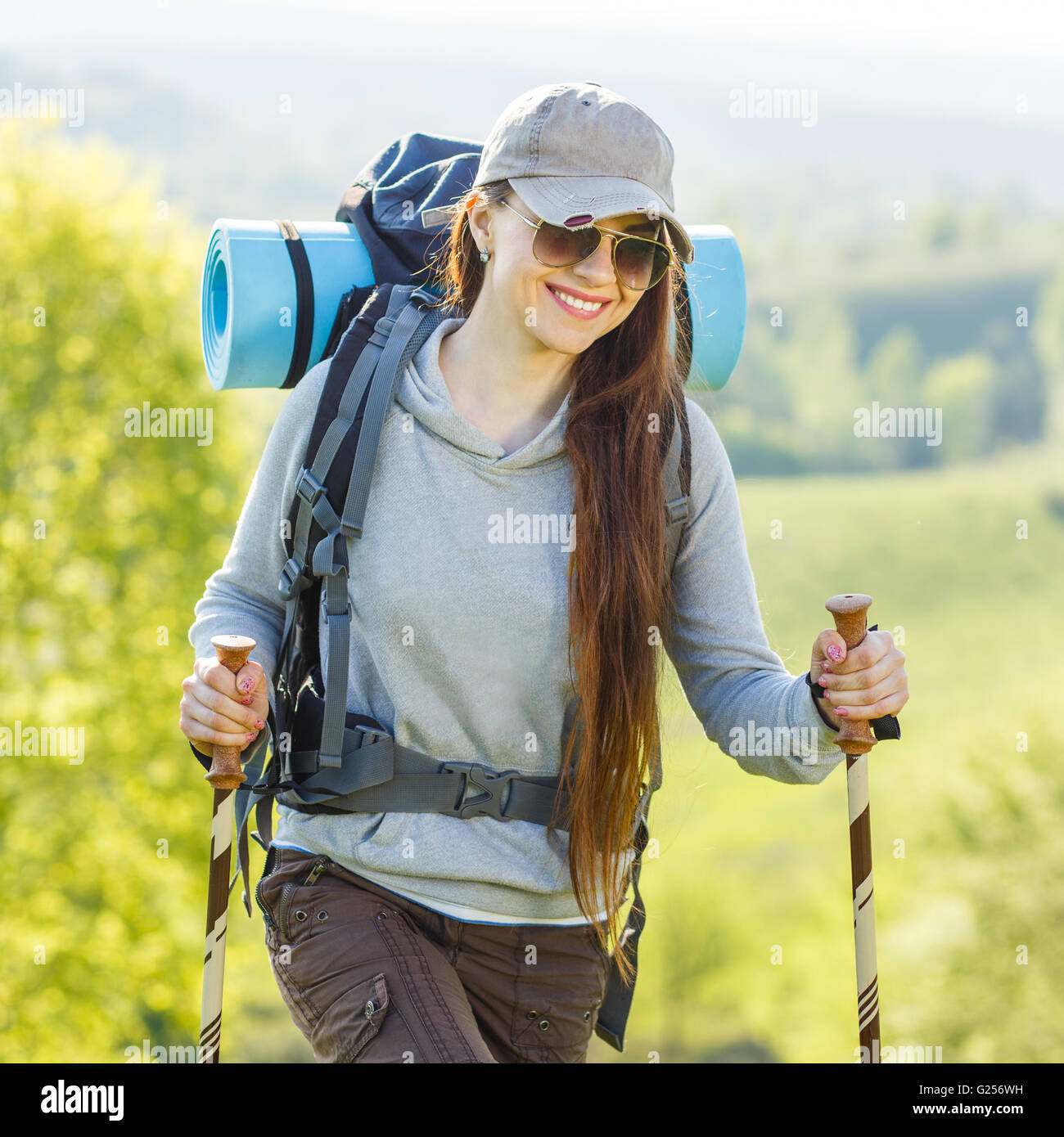 Hiker backpacker girl enjoying journey in countryside. Smiling girl in ...