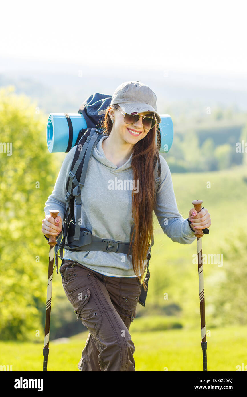 Woman hiker smiling and walking with hiking poles. Stock Photo by  ©ferrerivideo 163777938