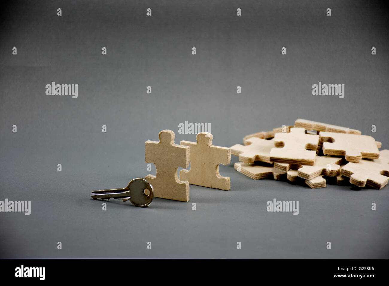 Puzzle made of wood with key.on gray.business idea,MLM,On gray background.Center Stock Photo