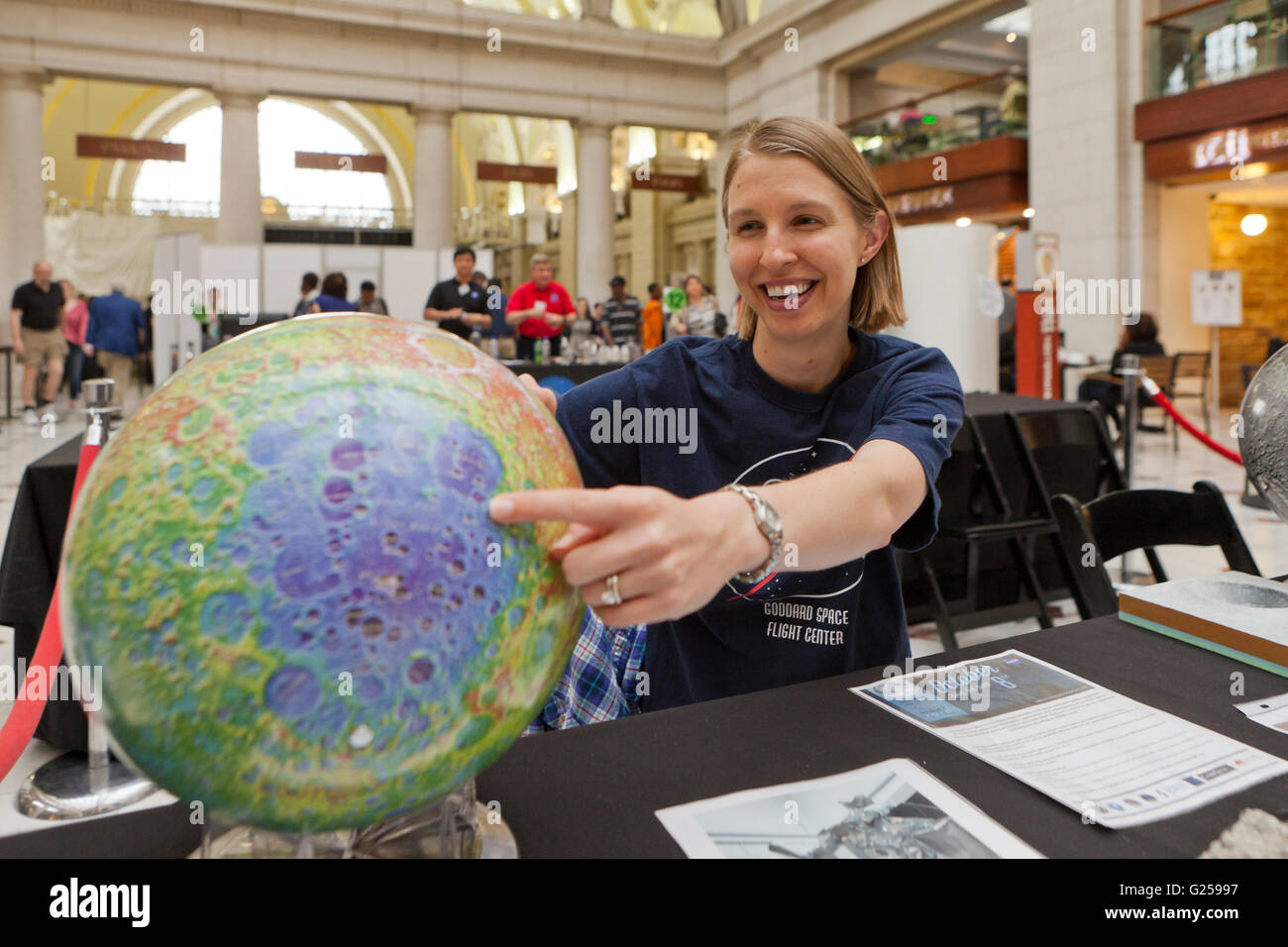 NASA planetary scientist pointing at moon globe - USA Stock Photo