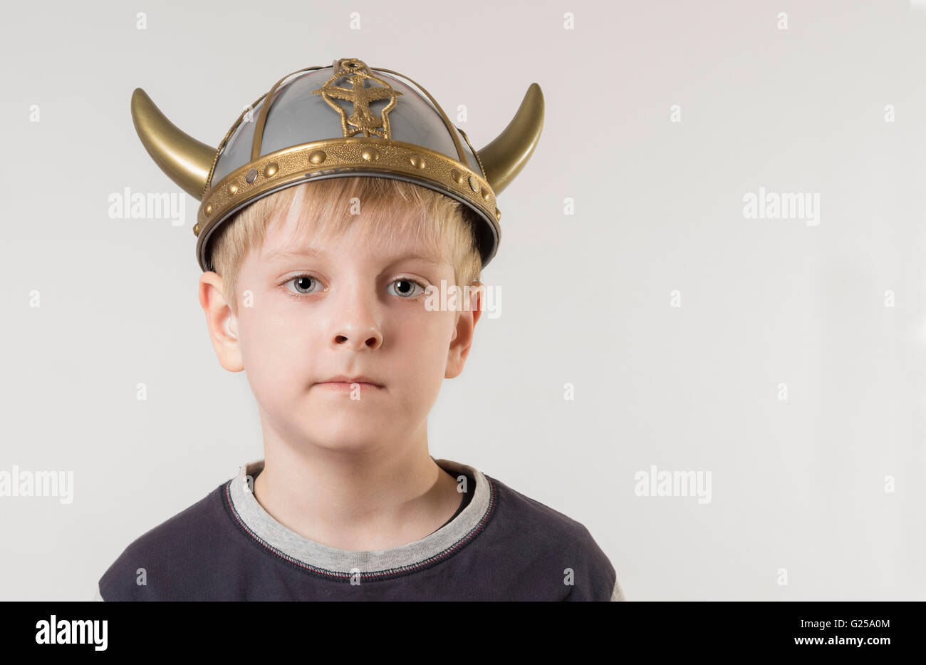 Portrait of a boy wearing a plastic toy Viking helmet Stock Photo