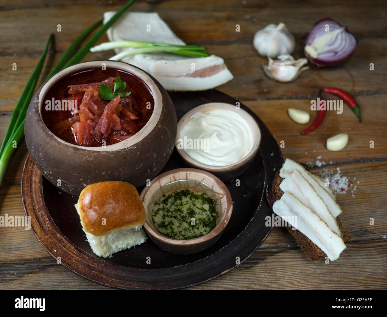 Traditional borscht soup with bread, sour cream and chopped herbs Stock Photo