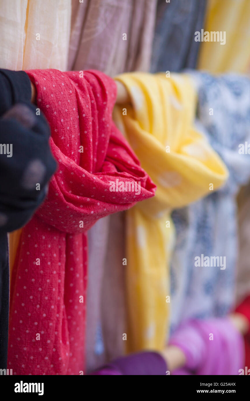 Close-up of multi coloured scarves hanging on rail Stock Photo