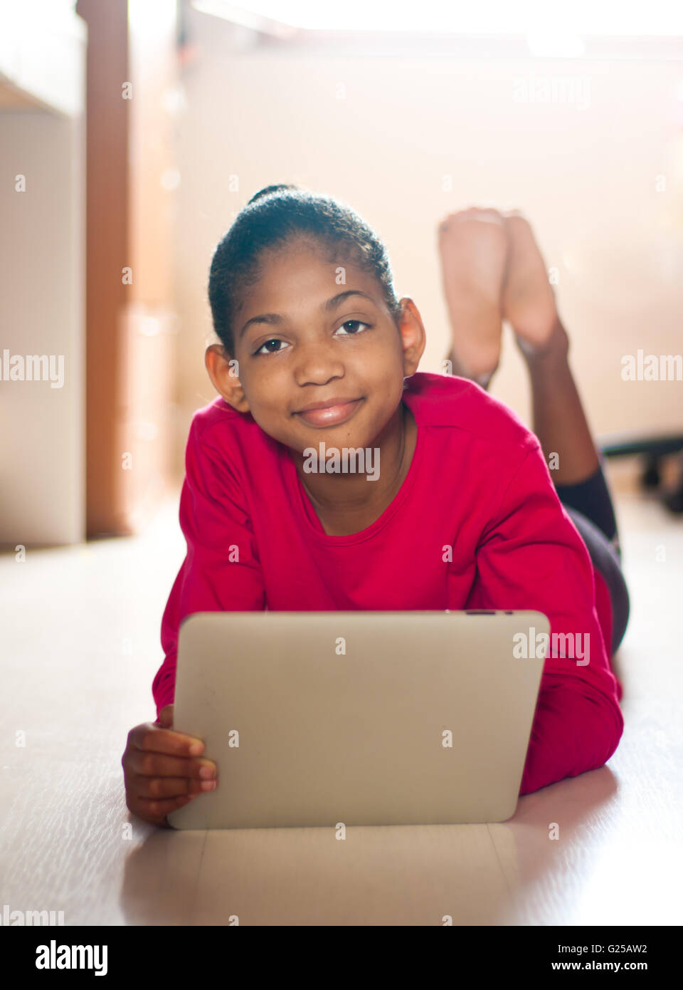 Girl lying on bedroom floor with digital tablet Stock Photo Alamy