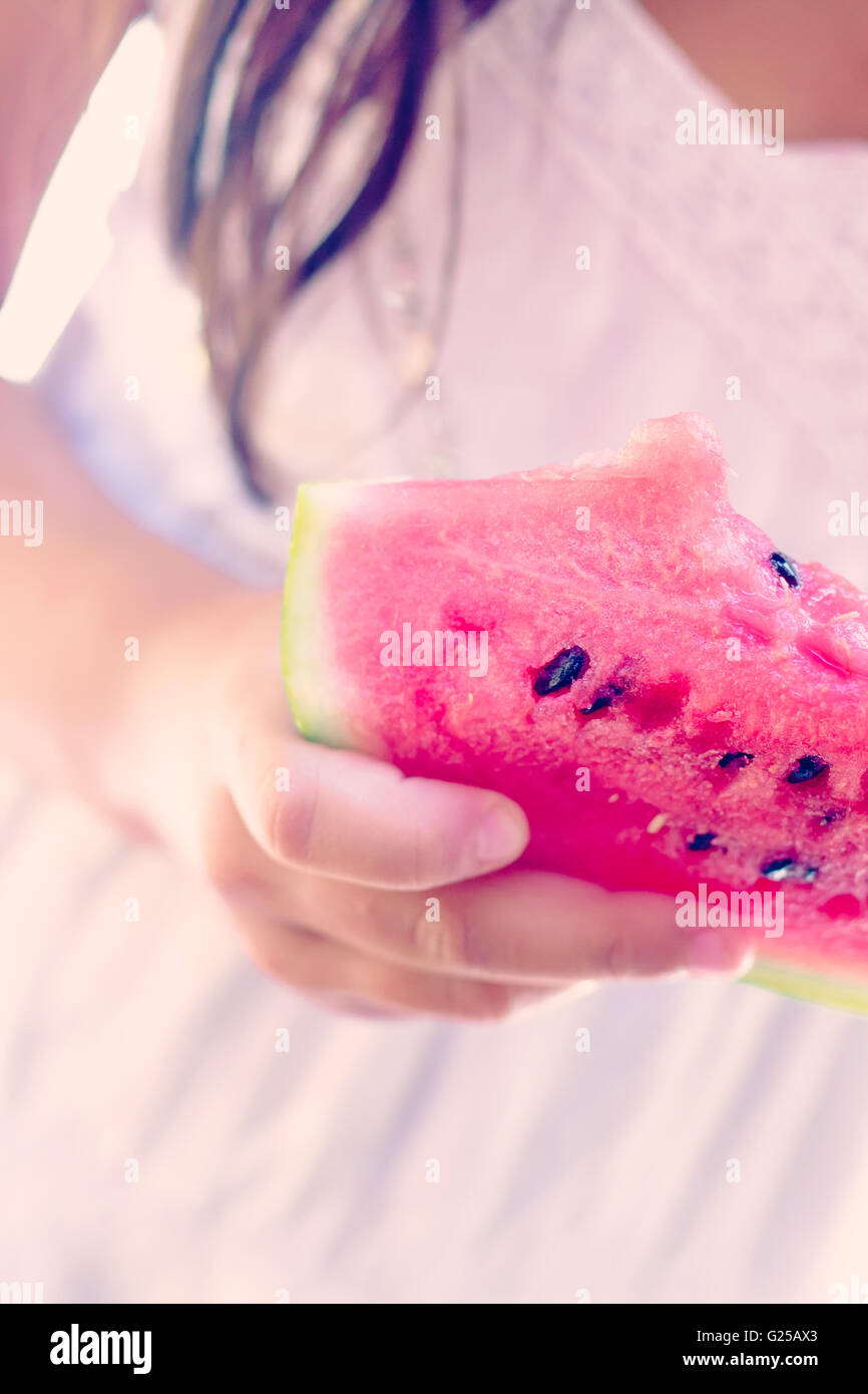 Close-up of girl holding slice of watermelon Stock Photo