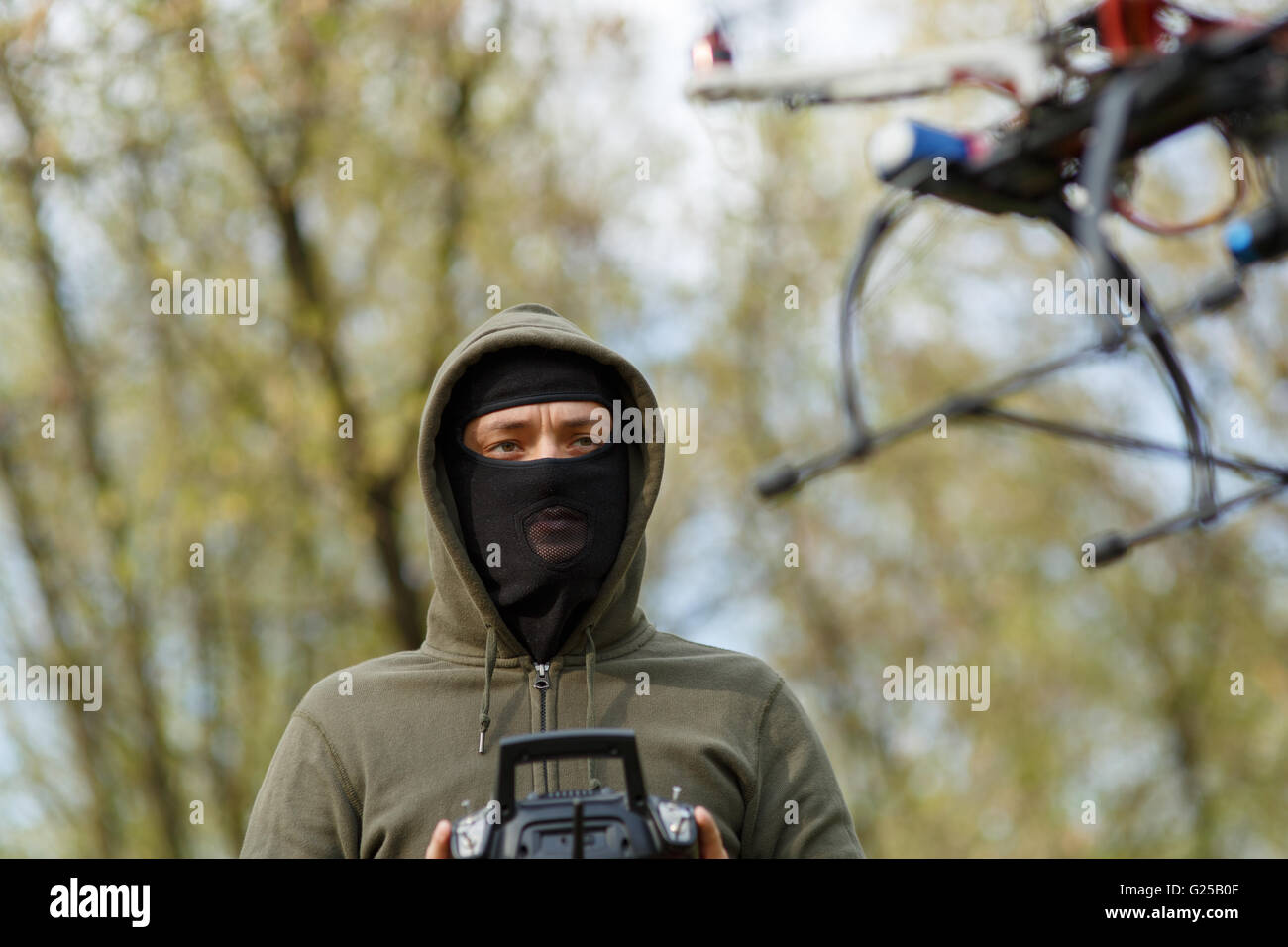 Man in mask operating a drone with remote control. Stock Photo