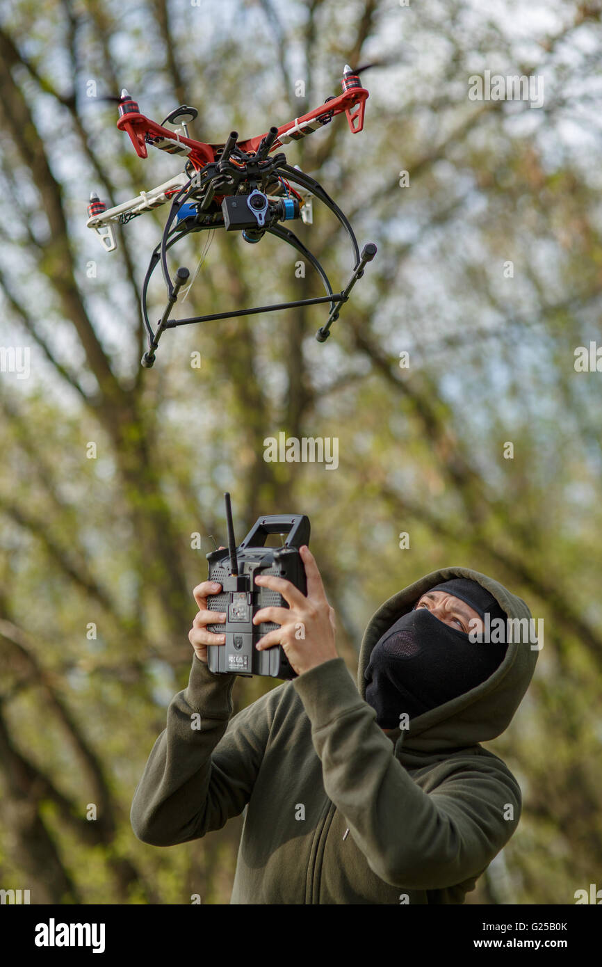 Man in mask operating a drone with remote control. Stock Photo