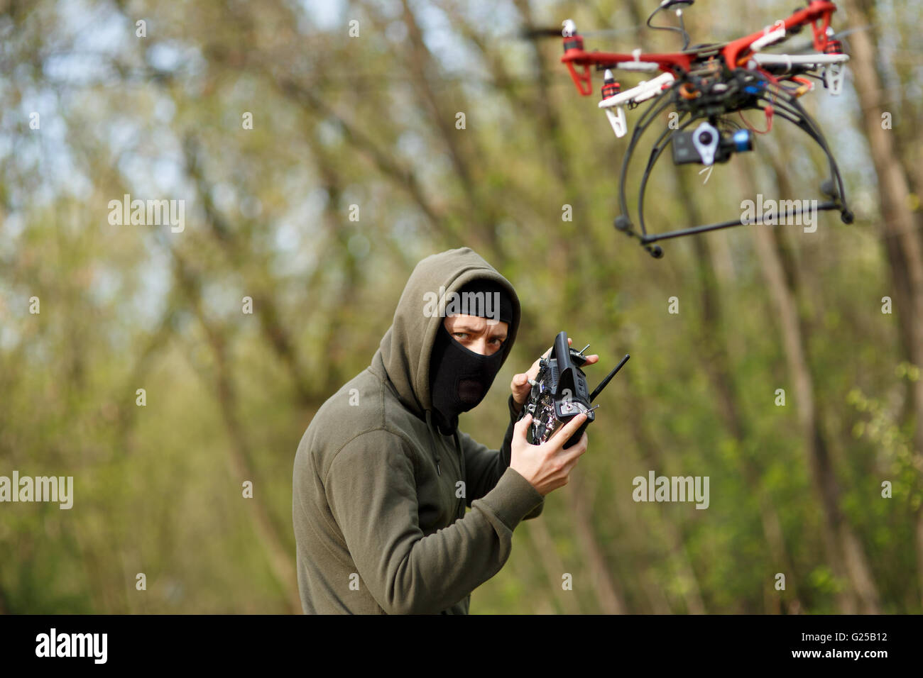 Man in mask operating a drone with remote control. Stock Photo