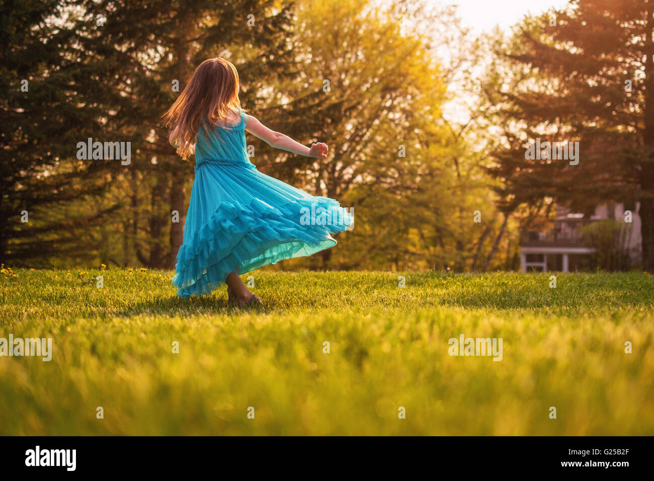 Girl in garden spinning around in a dress Stock Photo