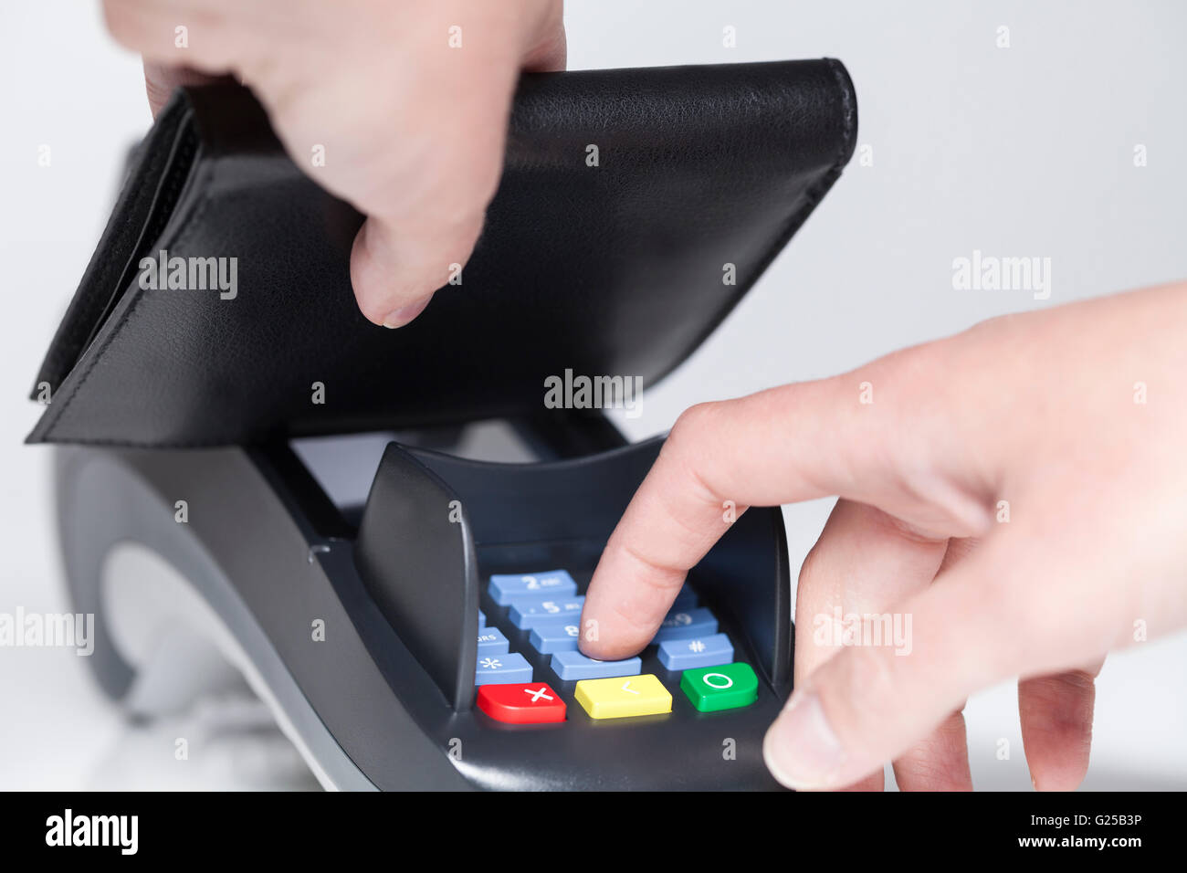 Entering code in a card reader and hiding with purse Stock Photo