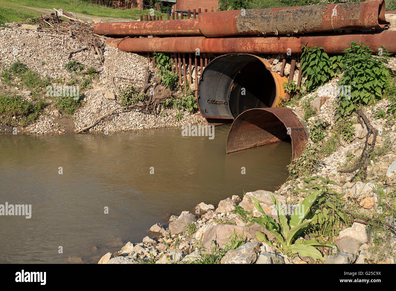 Dirty drain polluting a river Stock Photo