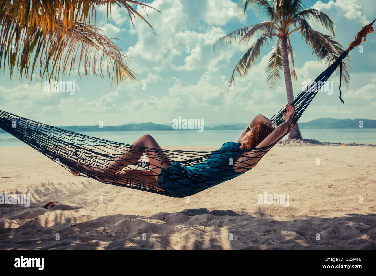 A young woman is relaxing in a hammock on a tropical beach Stock Photo ...