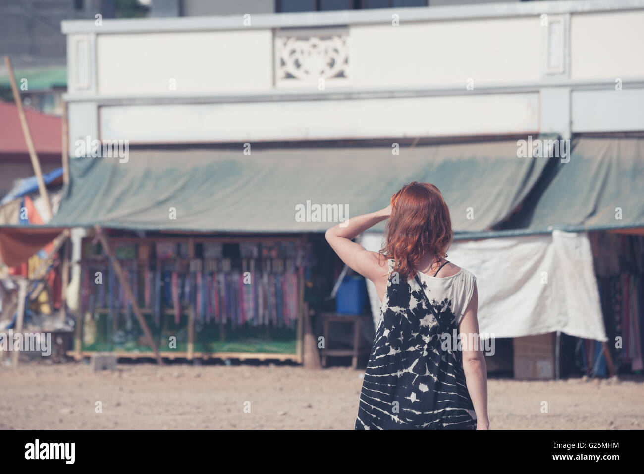 A young caucasian woman is walking around a small town in a developing country Stock Photo