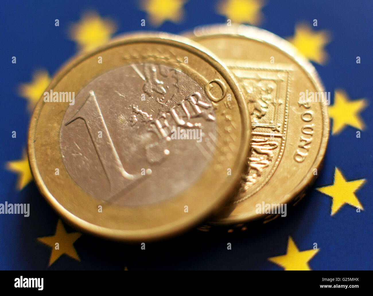 A 1 euro coin and a One Pound coin placed on a backdrop of The European flag, in London. Stock Photo