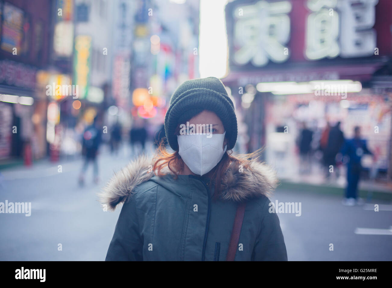 A young caucasian woman is wearing a face mask in Japan Stock Photo