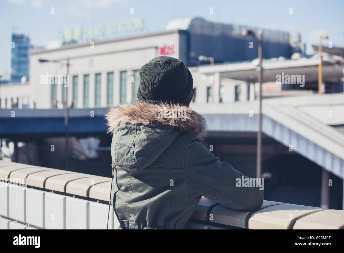 A ywoman is looking at a train station in the city in winter Stock Photo