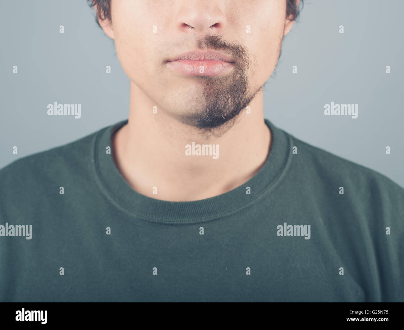 A young man with a half shaved beard Stock Photo
