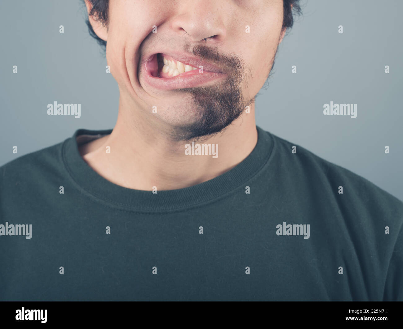 A man with a half shaved beard is pulling faces Stock Photo