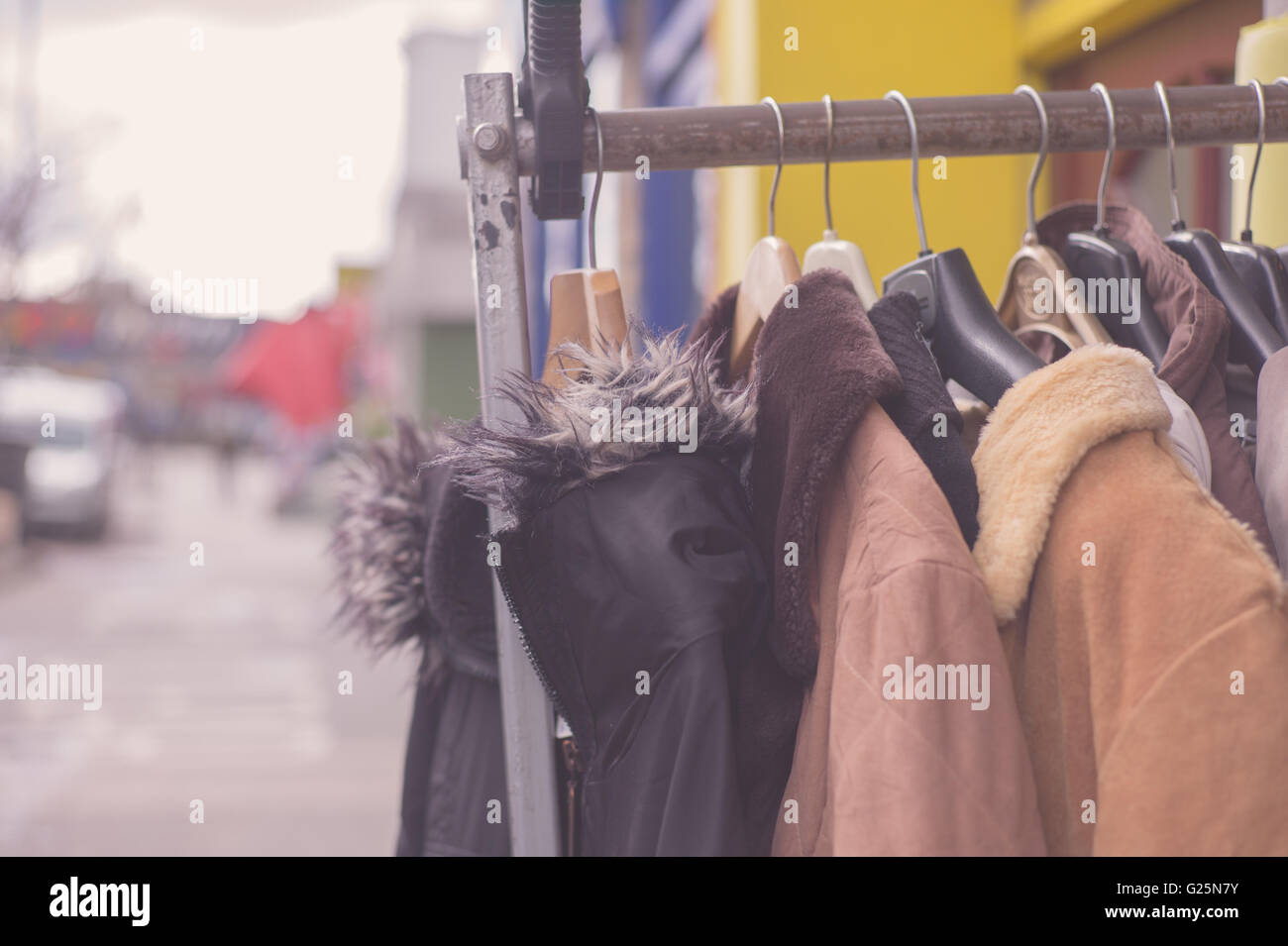 A bunch of winter jackets hanging on a rail outside Stock Photo - Alamy