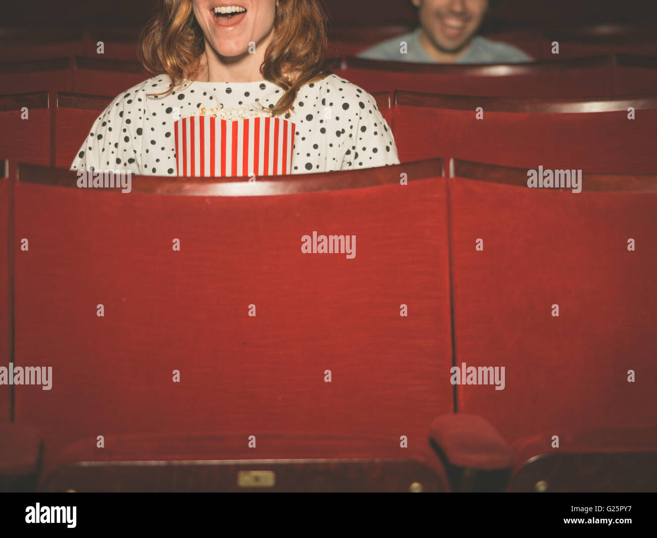 A couple of people are watching a film in a movie theater Stock Photo
