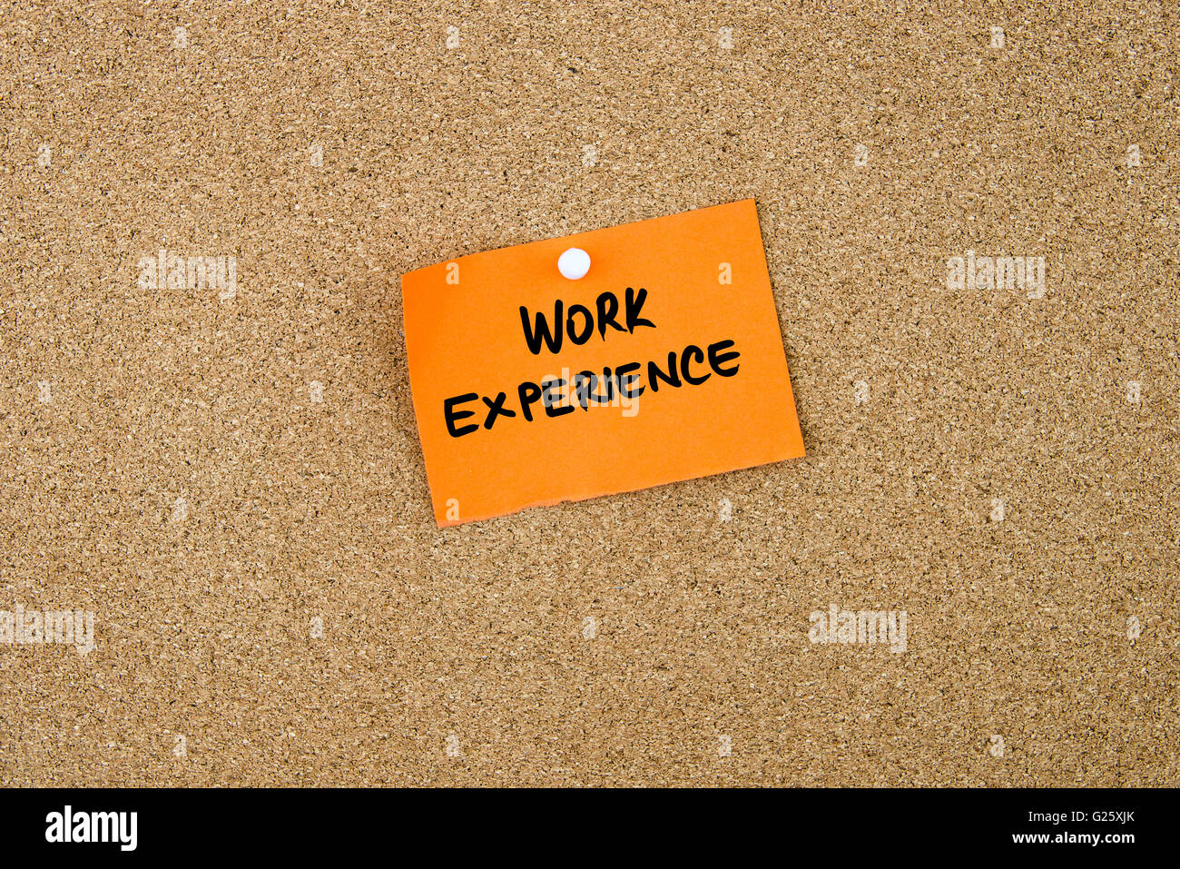 WORK EXPERIENCE written on orange paper note pinned on cork board with white thumbtacks, copy space available Stock Photo