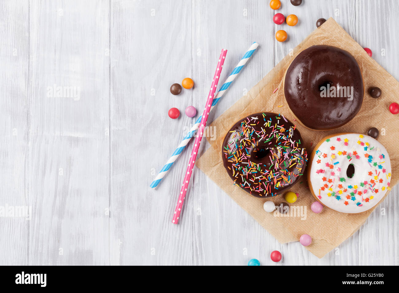 Colorful donuts on wooden table. Top view with copy space Stock Photo ...