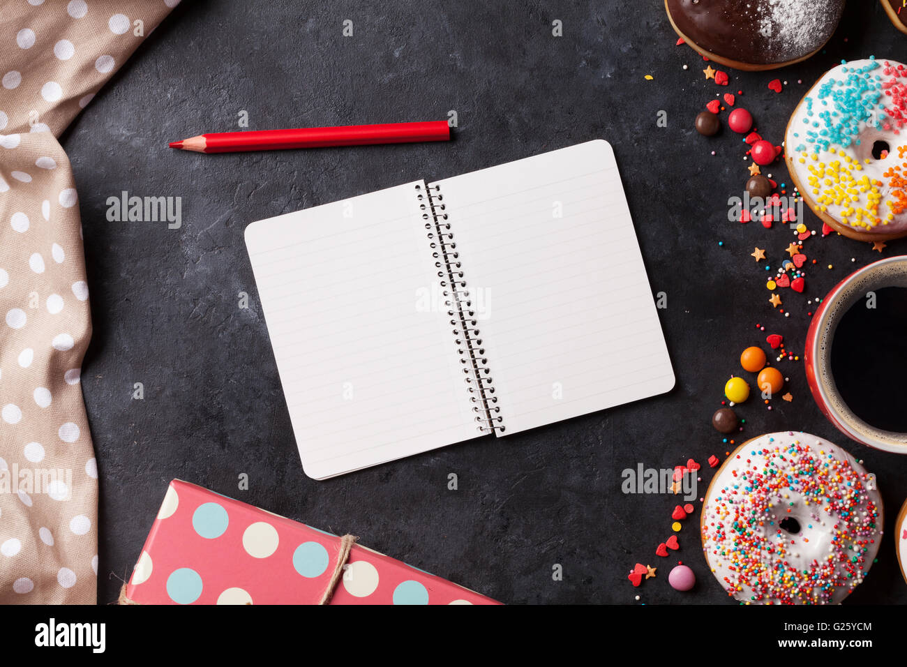 Notepad, donuts and coffee on stone table. Top view with copy space ...