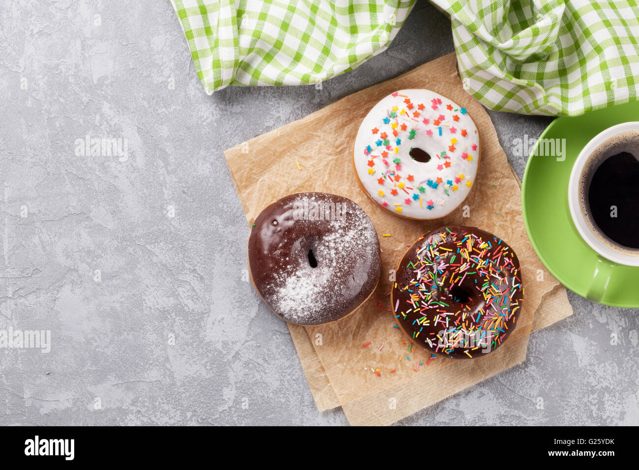 Colorful donuts and coffee on stone table. Top view with copy space ...