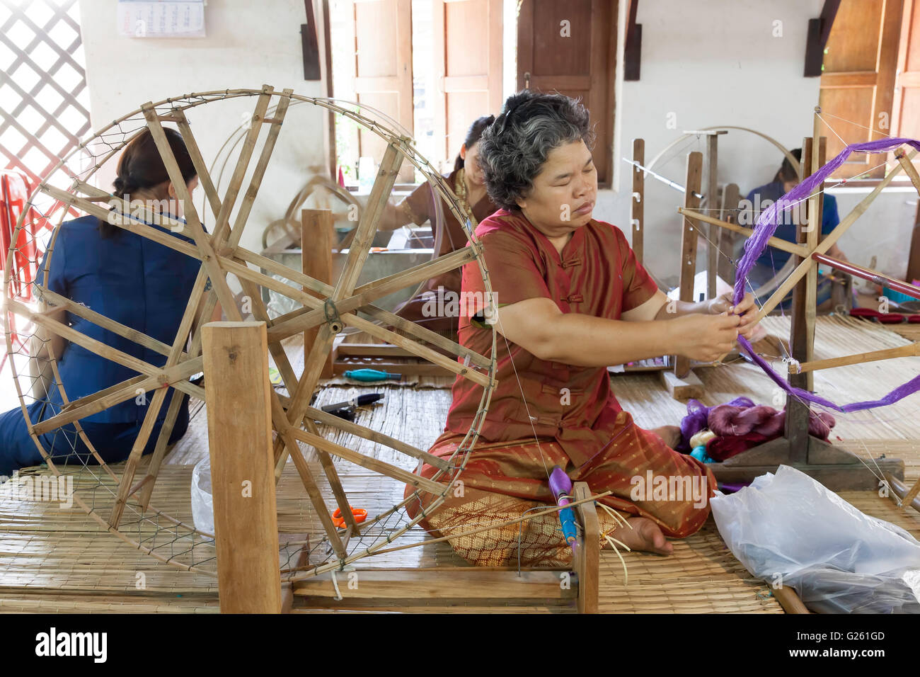 Thai women working with Old Silk weaving Handicraft machine Tai Dam Style in silk factory in Northern Thailand Stock Photo