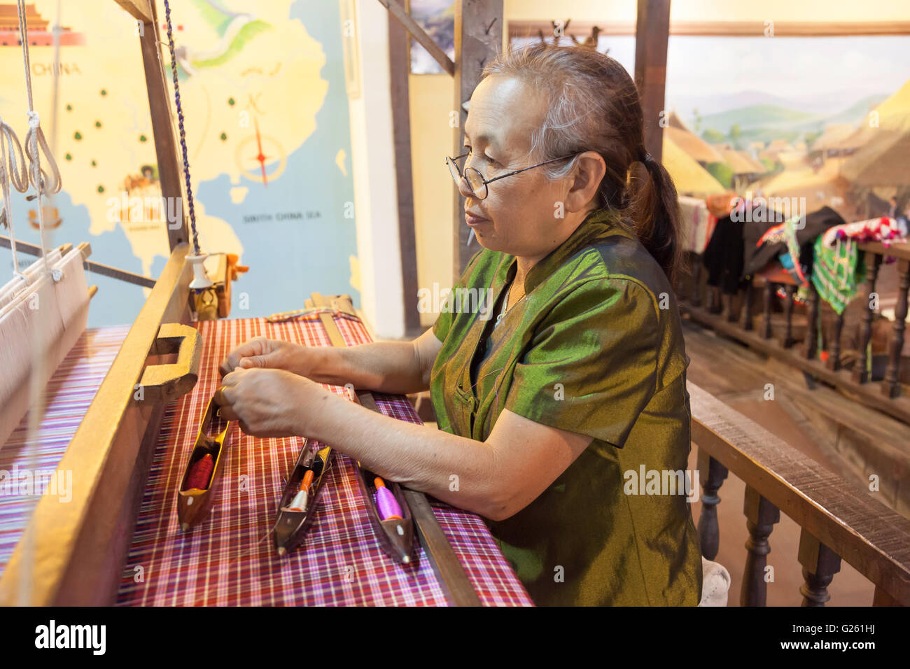 Thai woman working with Old Silk weaving Handicraft machine Tai Dam Style in silk factory in Northern Thailand Stock Photo