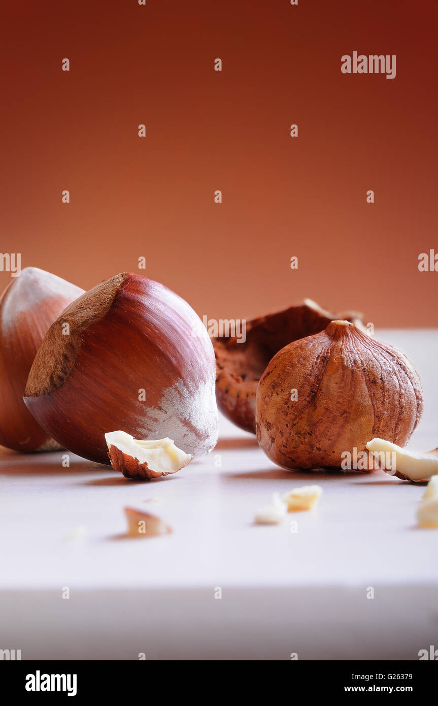 group of hazelnuts in shell and shelled on a white wooden table and