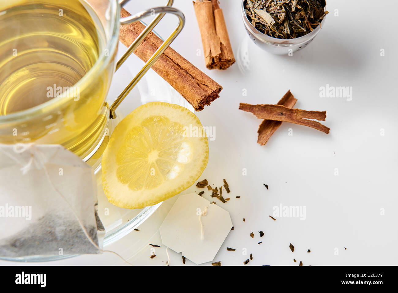 Glass cup green tea with cinnamon stick and lemon on a table in the living room. Horizontal composition. Top view. Stock Photo