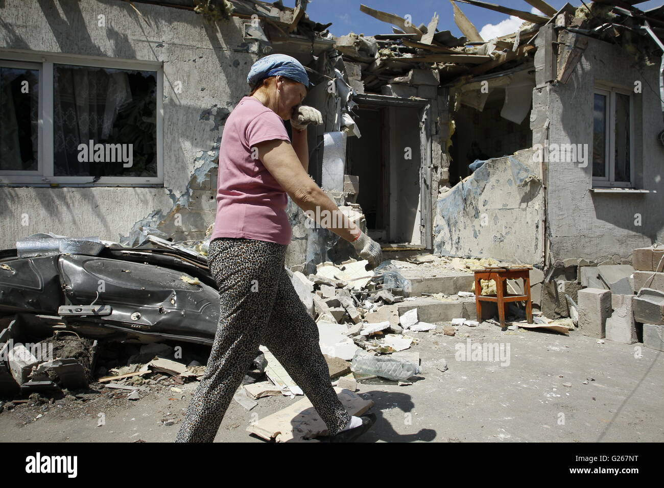 Donetsk, Ukraine. 24th May, 2016. A woman reacts next to her destroyed home after shelling in rebels controlled Staromykhaylivka village near Donetsk, Ukraine, May 24, 2016. Kremlin spokesman Dmitry Peskov confirmed that the Special Monitoring Mission to Ukraine under the Organization for Security and Co-operation in Europe is being discussed. Credit:  Alexander Ermochenko/Xinhua/Alamy Live News Stock Photo