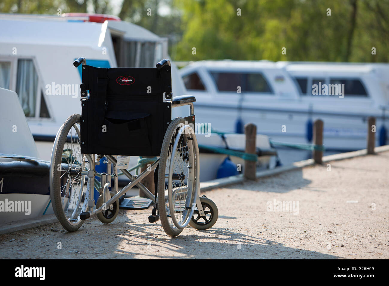 Wheelchair parked beside moored motor cruiser at Wroxham Stock Photo