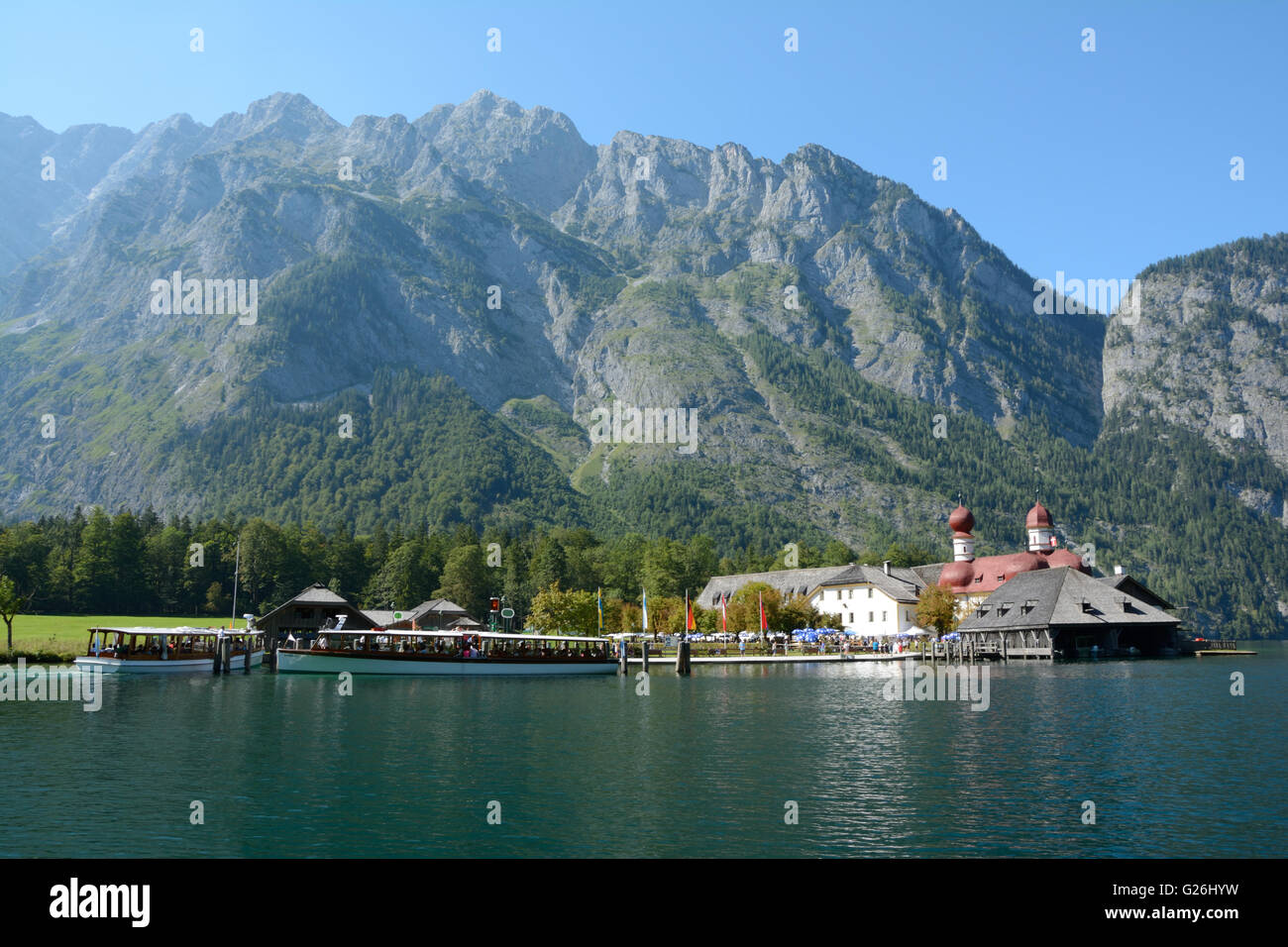 Schonau am Konigssee, Germany - August 30, 2015: Mountains, St. Bartholoma church, other buildings and ships at Koenigssee lake Stock Photo