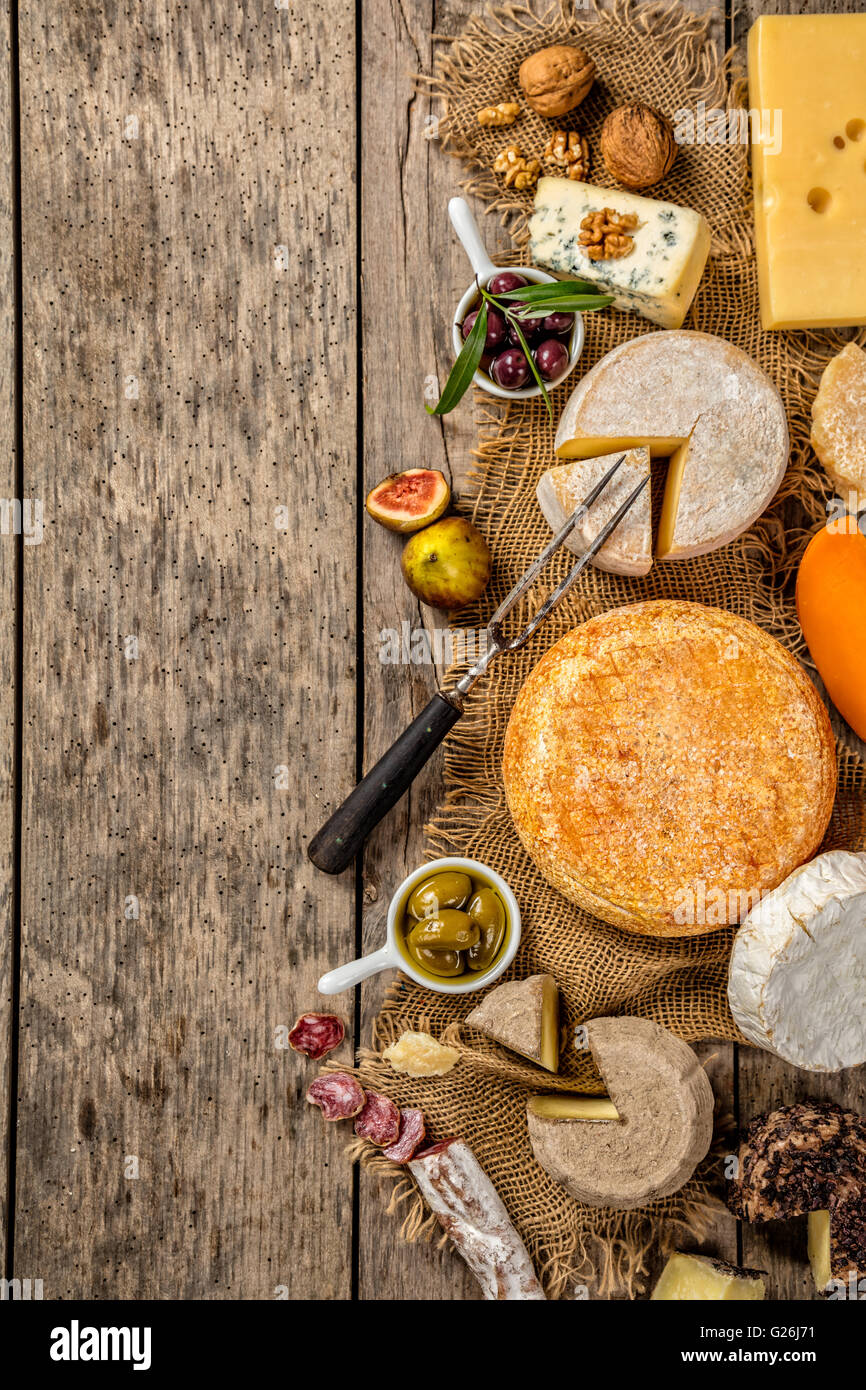 Various kind of traditional cheese and delicacy suitable for wine, placed on wood, shot from high angle view. Stock Photo