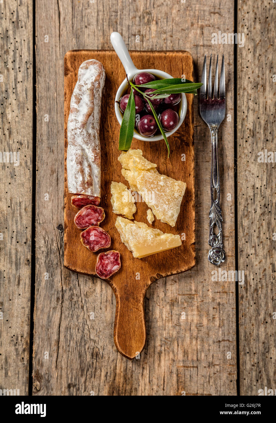 Various kind of traditional cheese and delicacy suitable for wine, placed on wooden cutting board, shot from high angle view. Stock Photo