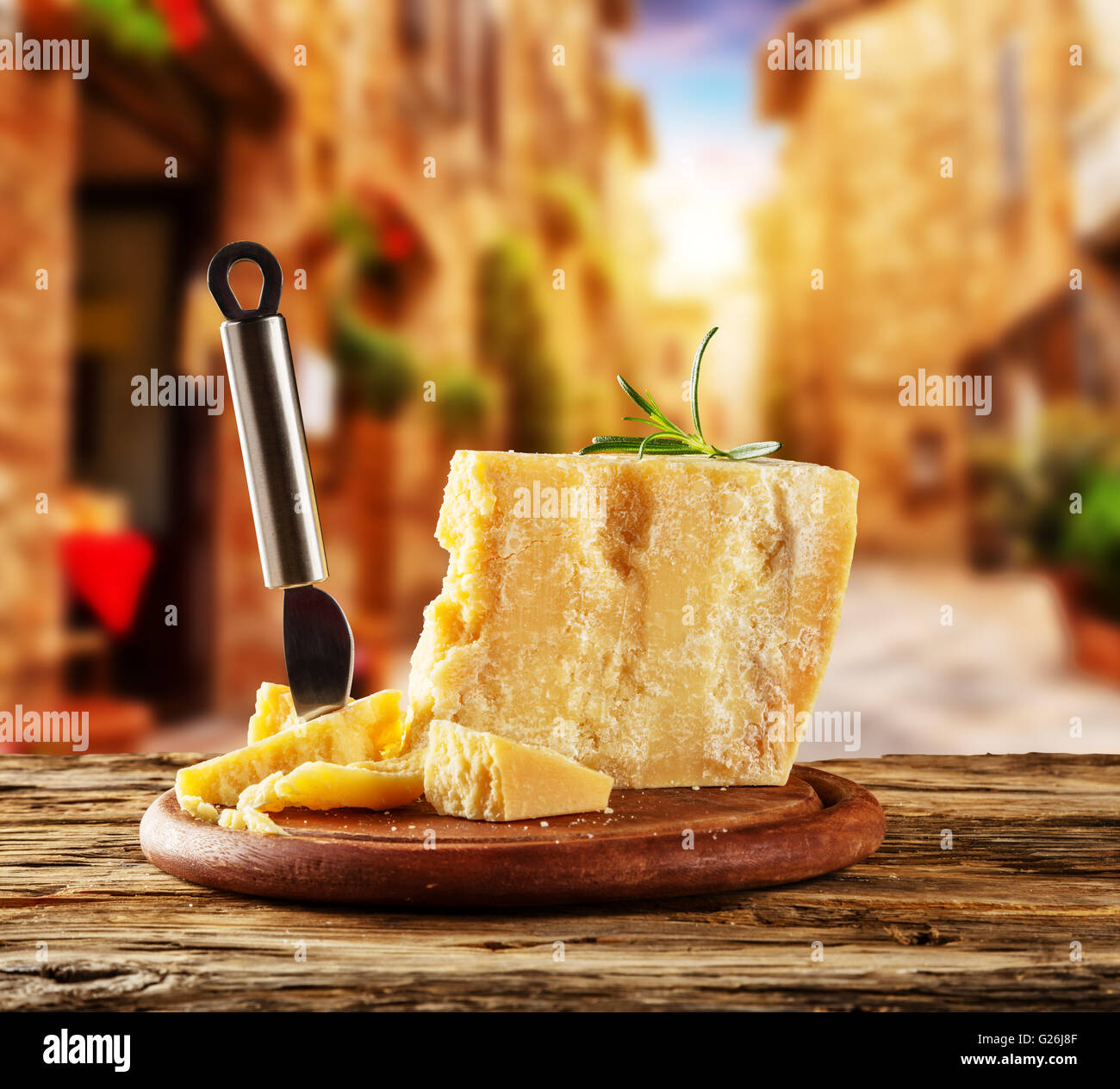 Parmesan cheese on cutting board placed on wood, blur old street on background Stock Photo