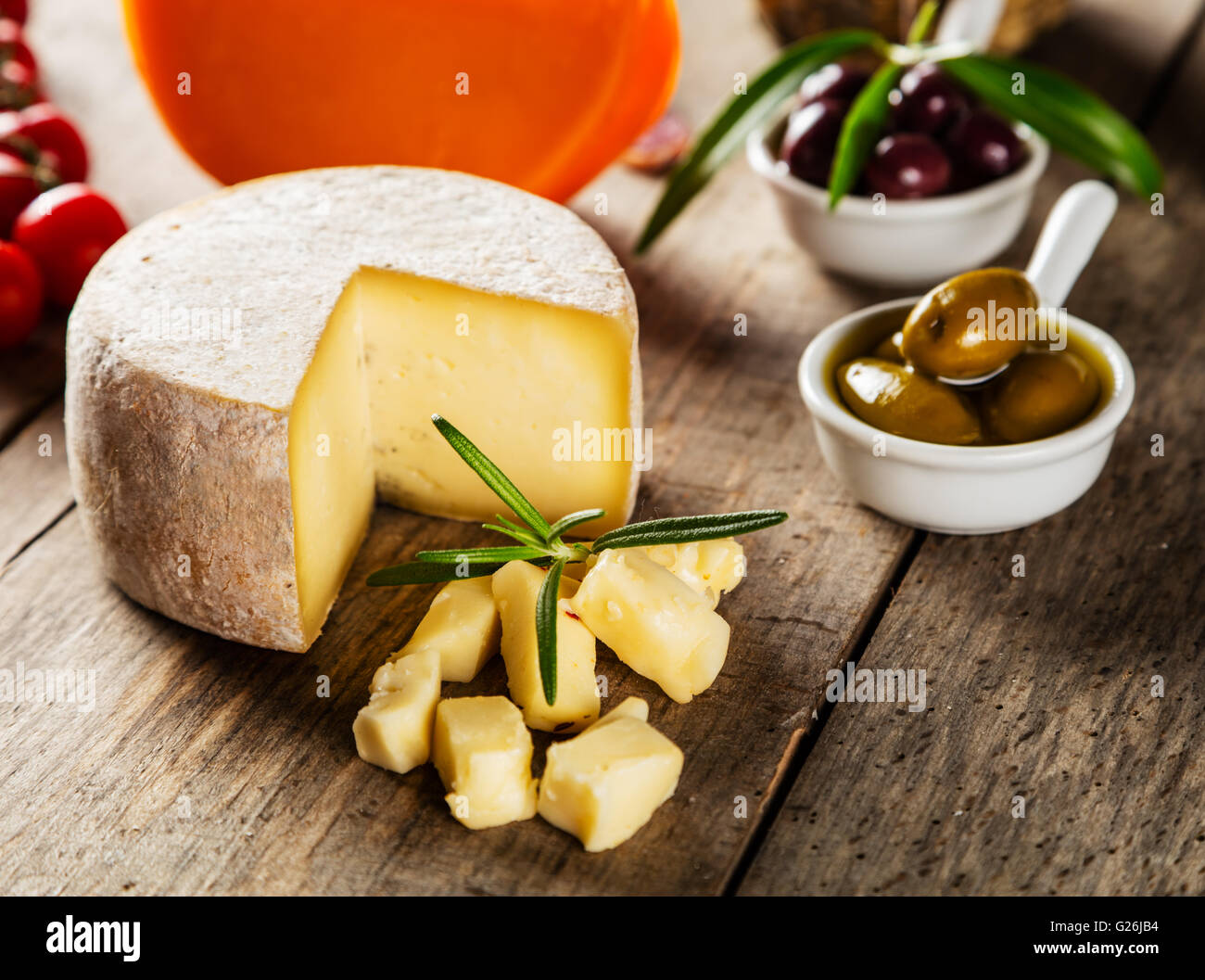 Parmesan cheese on cutting board placed on wood, low depth of focus Stock Photo