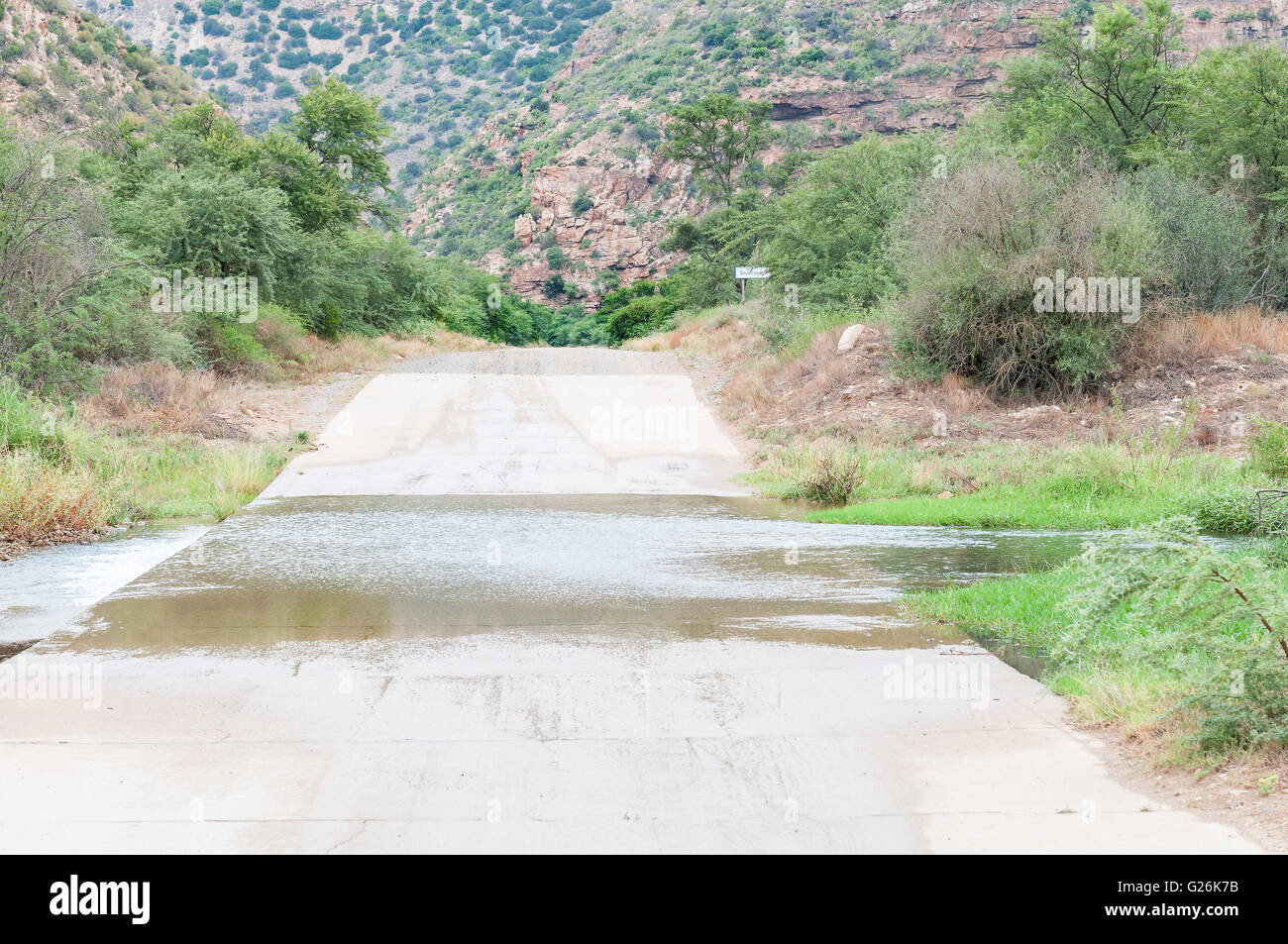 The road through  the Baviaanskloof (baboon valley) crosses the Baviaans River on a concrete causeway Stock Photo