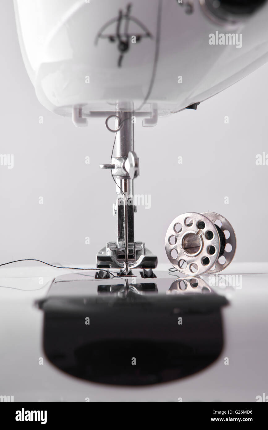 Front detail sewing machine needle and thread spool. Vertical