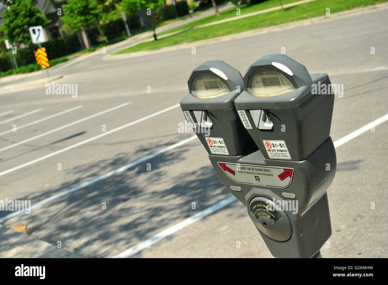 A Canadian parking meter by a row of empty parking spaces in London, Ontario. Stock Photo